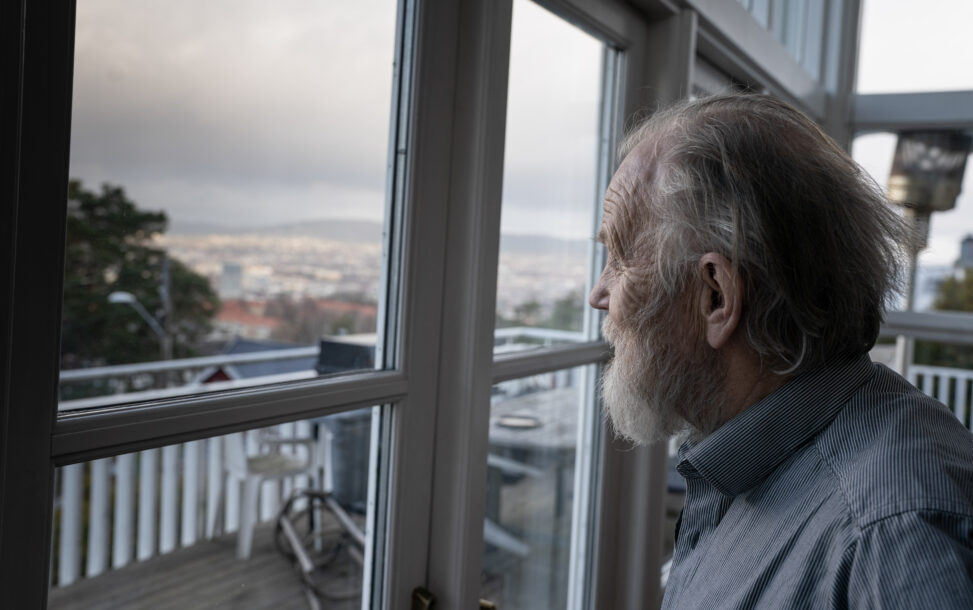 Harald Lunde ser ut av vinduet hjemme på Ekeberg