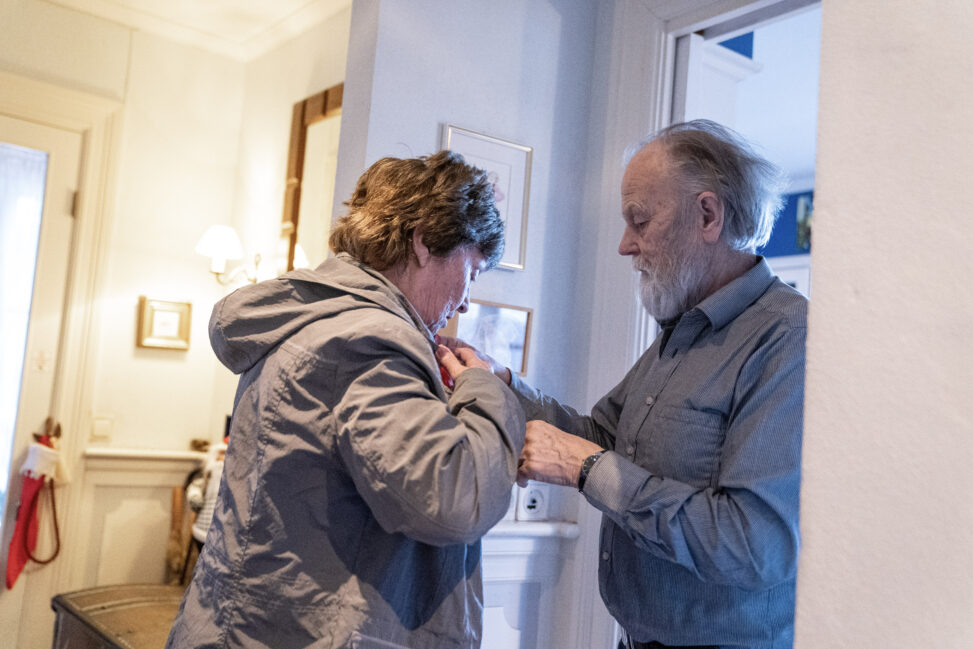 Harald Lunde hjelper kona med å få på seg ytterjakken.